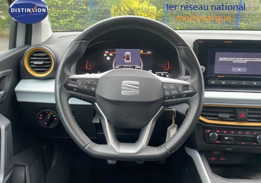 Vue centrée sur le volant et le tableau de bord du SEAT Arona 2025, intérieur noir avec touches jaunes.
