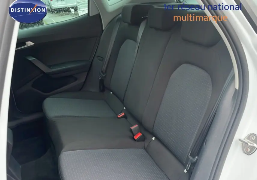 Vue intérieure côté droit montrant la banquette arrière en tissu noir avec détails gris d'un SEAT Arona blanc 2025.