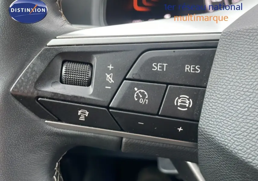 Gros plan sur les commandes au volant du SEAT Arona 2025, boutons de régulateur de vitesse et assistance au maintien de voie.