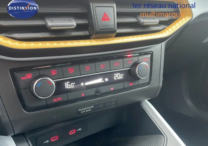 Vue rapprochée du tableau de bord de la SEAT Arona 2025, mettant en valeur la climatisation digitale et les commandes noires.