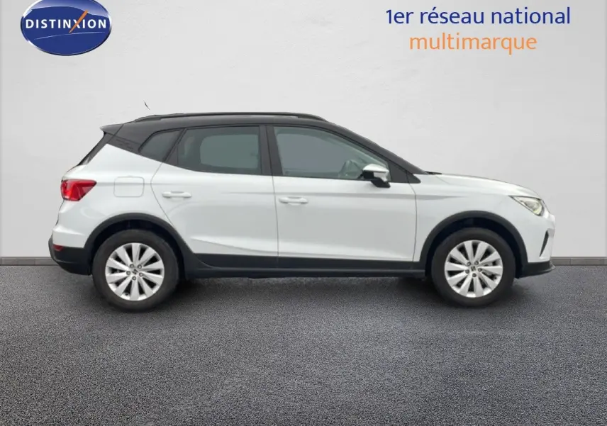 Vue latérale droite du SEAT Arona blanc alpin avec toit noir, soulignant son profil compact et moderne.