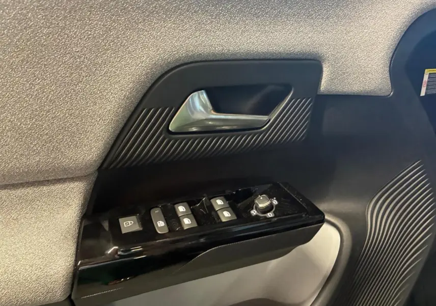 Détail de la porte côté conducteur du Citroën C5 Aircross 2026 vert, avec commandes de vitres et poignée argentée.