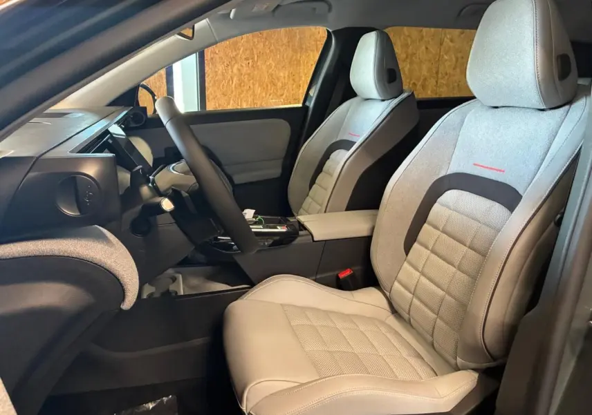 Vue intérieure côté gauche du Citroën C5 Aircross 2026, sièges gris clair avec surpiqûres rouges et tableau de bord moderne.