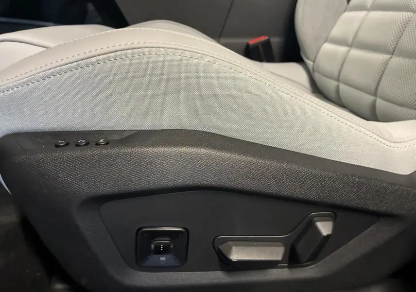 Détail des commandes électriques sur le côté gauche du siège avant gris clair du Citroën C5 Aircross II 1.2 hybride 2026.