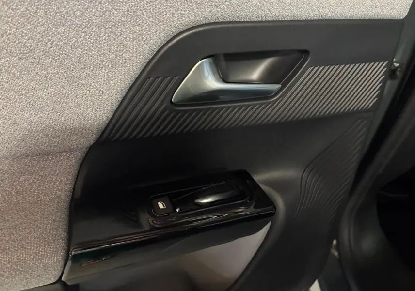 Détail de la porte intérieure côté gauche du Citroën C5 Aircross II vert, avec poignée argentée et commande de vitre noire.