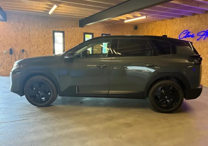 Vue latérale gauche du Citroën C5 Aircross 2026 vert, avec jantes noires et vitres teintées, en intérieur.