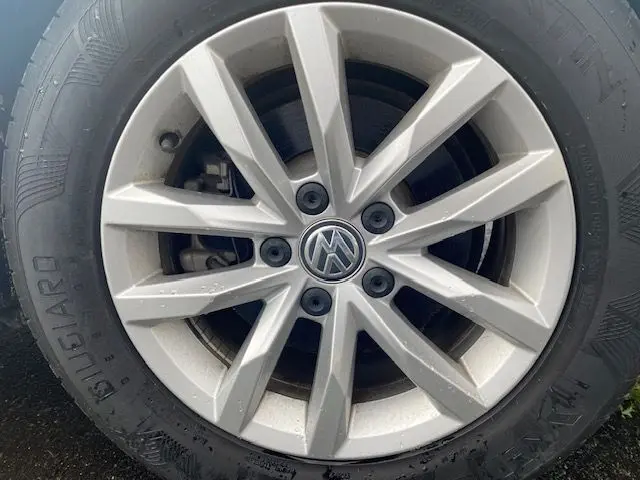 Gros plan sur la jante argentée d'une Volkswagen Passat 2015, mettant en valeur le logo VW central.