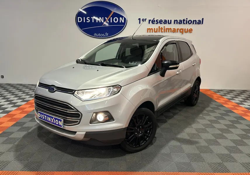 Ford EcoSport gris en 3/4 avant droit avec jantes noires et phares allumés dans un showroom