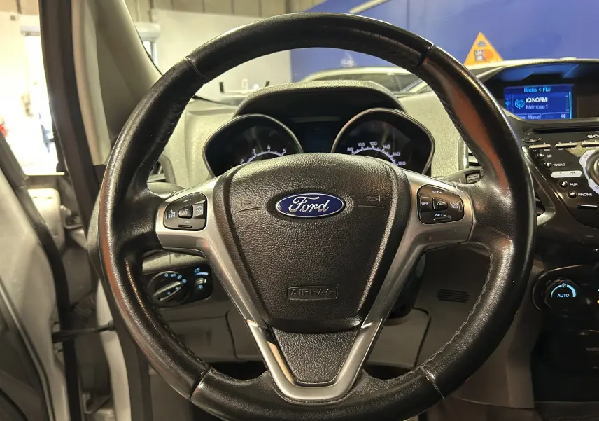 Volant en cuir noir de Ford EcoSport Titanium 2018, vue frontale centrée sur les commandes au volant et tableau de bord.