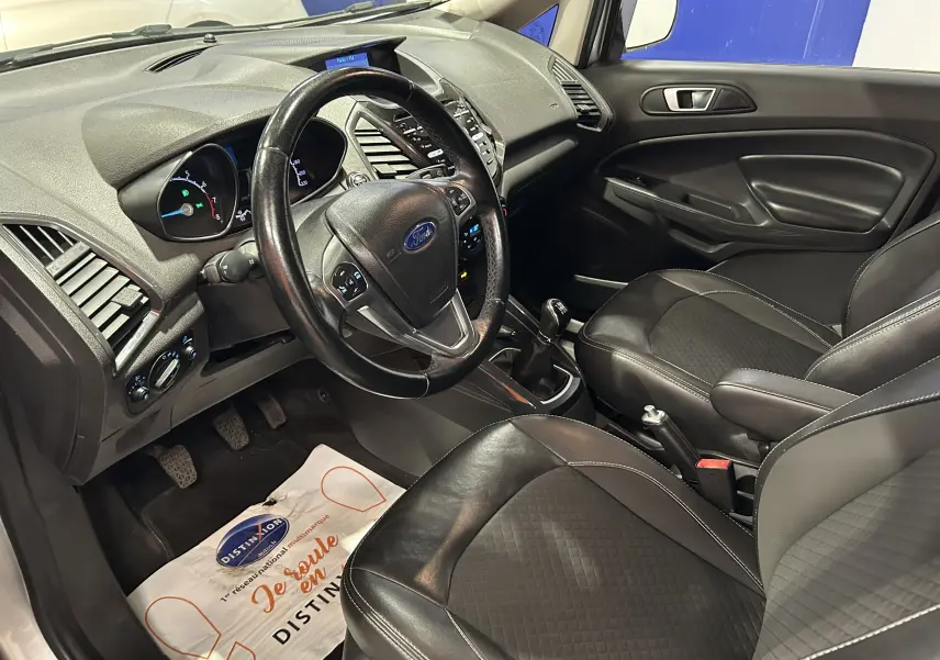 Vue intérieure côté conducteur du Ford EcoSport gris 2018, montrant le volant, tableau de bord et sièges en cuir noir.