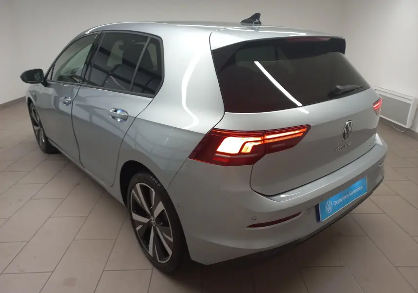 Vue 3/4 arrière droite d'une Volkswagen Golf 1.5 eHybrid 204 DSG6 argent Dolomite avec jantes alliage 18 pouces Catania.