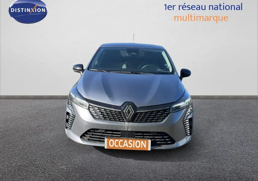 Vue frontale d'une Renault Clio gris schiste métal 2025 avec calandre moderne et phares LED allumés.