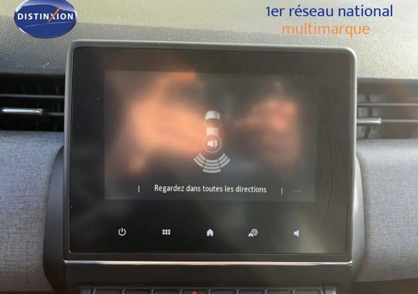 Écran tactile central de la Renault Clio gris schiste, affichant une alerte de surveillance des angles morts.