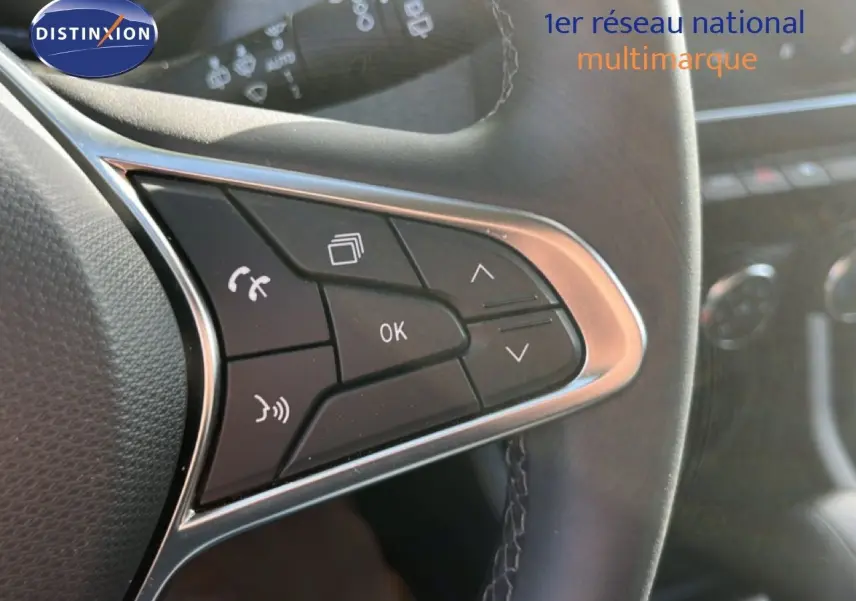 Gros plan sur les commandes multifonctions à droite du volant de la Renault Clio gris schiste métal, intérieur noir.