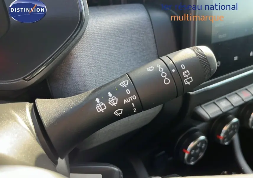 Gros plan sur la commande d’essuie-glace à gauche du volant dans l’habitacle d’une Renault Clio gris schiste métal.