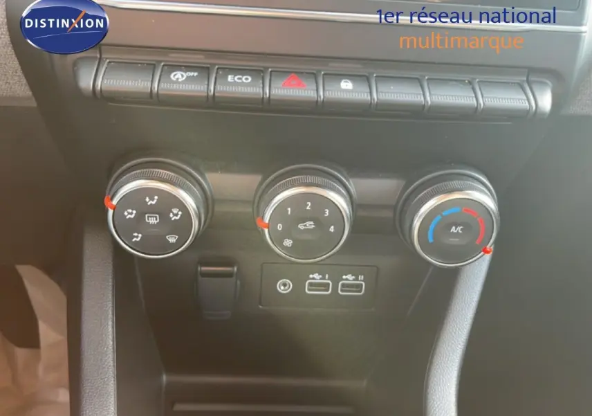 Vue rapprochée des commandes de climatisation et des ports USB du tableau de bord de la Renault Clio gris schiste 2025.