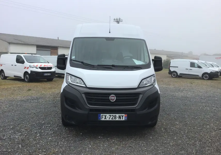 Vue frontale d’un fourgon FIAT Ducato blanc avec calandre noire et plaque d’immatriculation française visible.