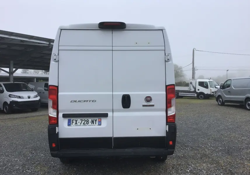 Vue arrière d'un FIAT Ducato Fourgon blanc, avec portes battantes fermées et plaques d'immatriculation françaises visibles.