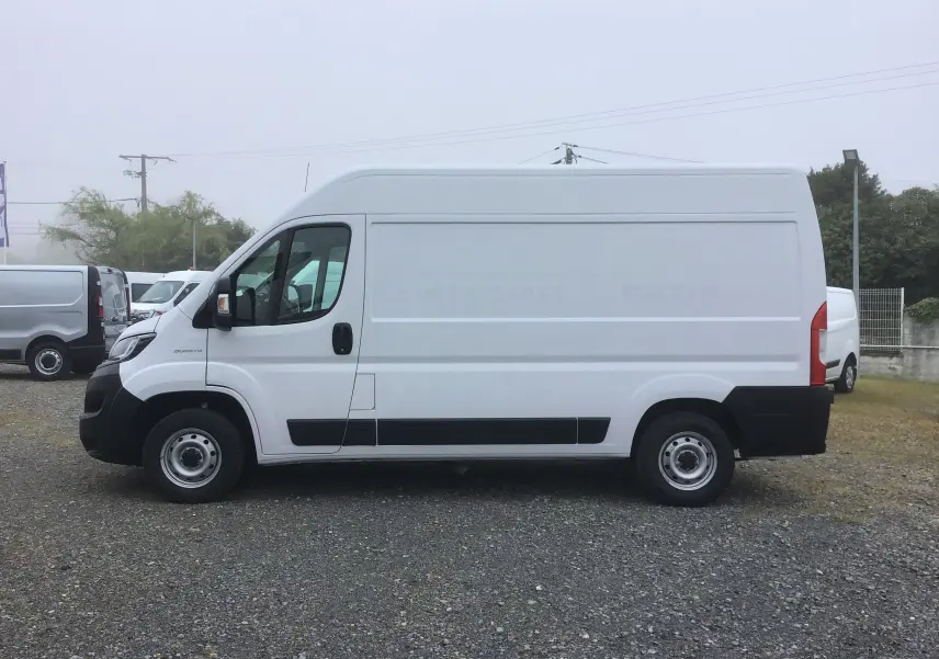 Fourgon blanc FIAT Ducato 35 MH2 vu de profil côté gauche sur un sol gravillonné, sans marquage visible.