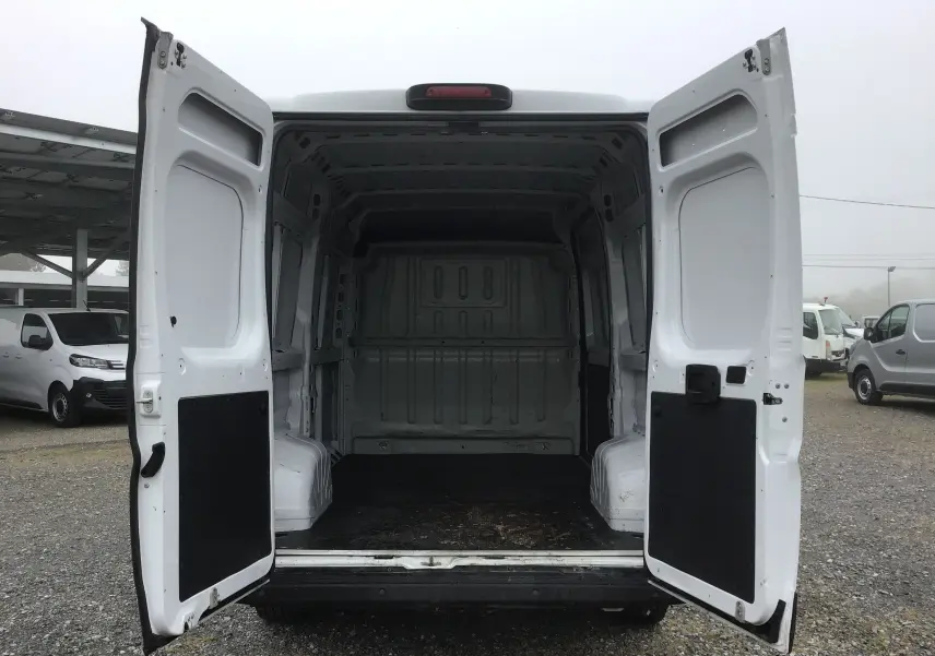 Vue arrière du FIAT Ducato Fourgon blanc 2021 avec portes arrière ouvertes, montrant l'espace de chargement vide.