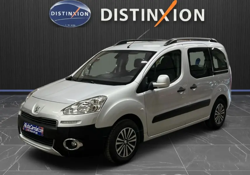 Peugeot Partner Tepee gris aluminium vu en 3/4 avant droit, avec barres de toit et jantes spécifiques.