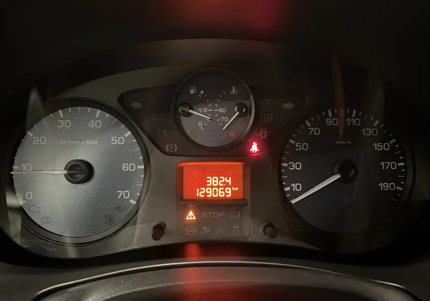 Vue rapprochée du tableau de bord du Peugeot Partner Tepee 2013, affichant compteurs et témoins lumineux allumés.