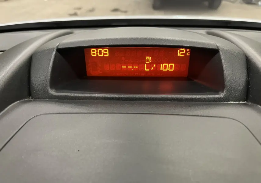 Affichage numérique orange du tableau de bord du Peugeot Partner Tepee 2013, indiquant l'heure et la température extérieure.