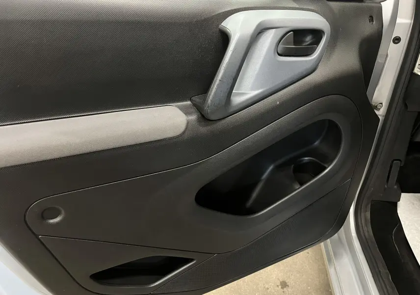 Vue rapprochée de la porte avant gauche gris aluminium du Peugeot Partner Tepee 2013 avec poignée intérieure grise.