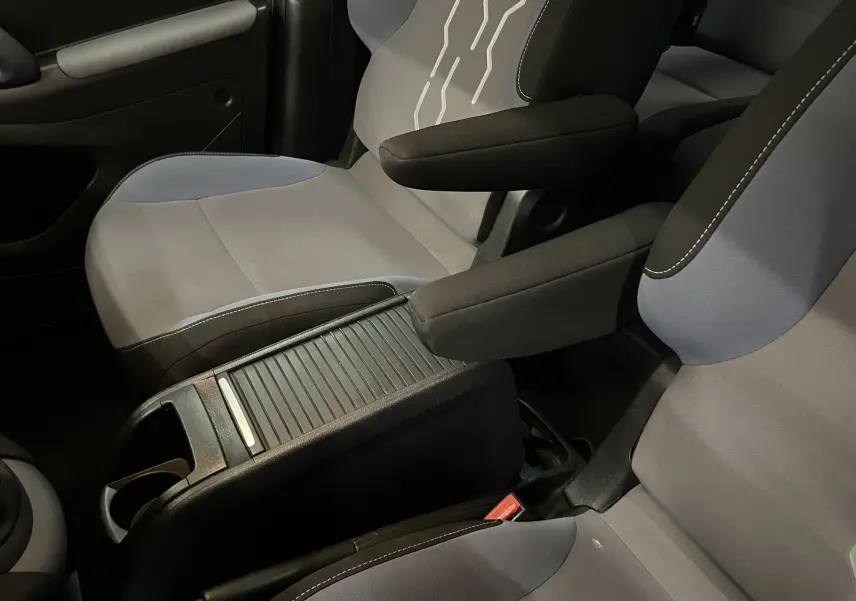 Vue rapprochée des sièges avant gris et bleu du Peugeot Partner Tepee 2013 avec accoudoirs et console centrale.