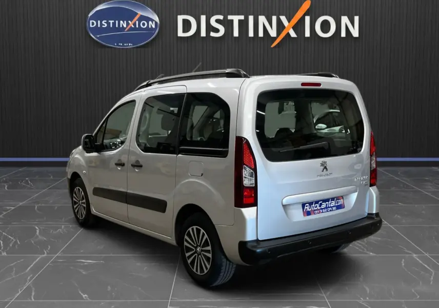 Peugeot Partner Tepee gris aluminium vu en 3/4 arrière droit, avec vitres teintées et barres de toit noires.