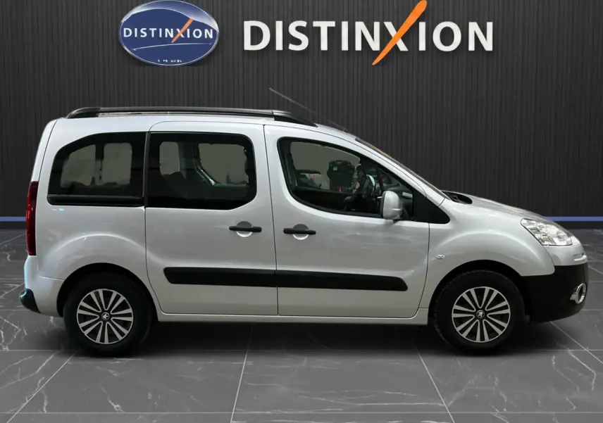 Profil droit du Peugeot Partner Tepee gris aluminium de 2013 avec barres de toit et vitres arrière teintées.