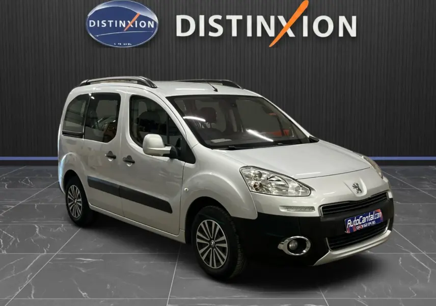 Peugeot Partner Tepee gris aluminium en 3/4 avant droit, avec barres de toit et protections latérales noires visibles.