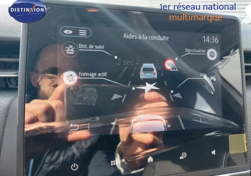Écran tactile du système d’aide à la conduite de la Renault Clio blanche, affichant régulateur et détection panneaux.