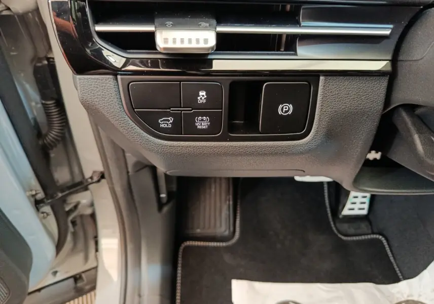Vue intérieure côté conducteur du tableau de bord et commandes basses d’un KIA Sportage gris clair 2026.