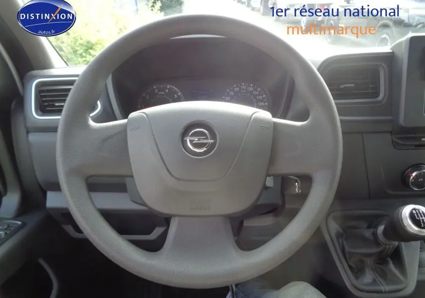 Vue intérieure centrée sur le volant gris d'un Opel Movano Fourgon 2022 avec levier de vitesse manuel visible.