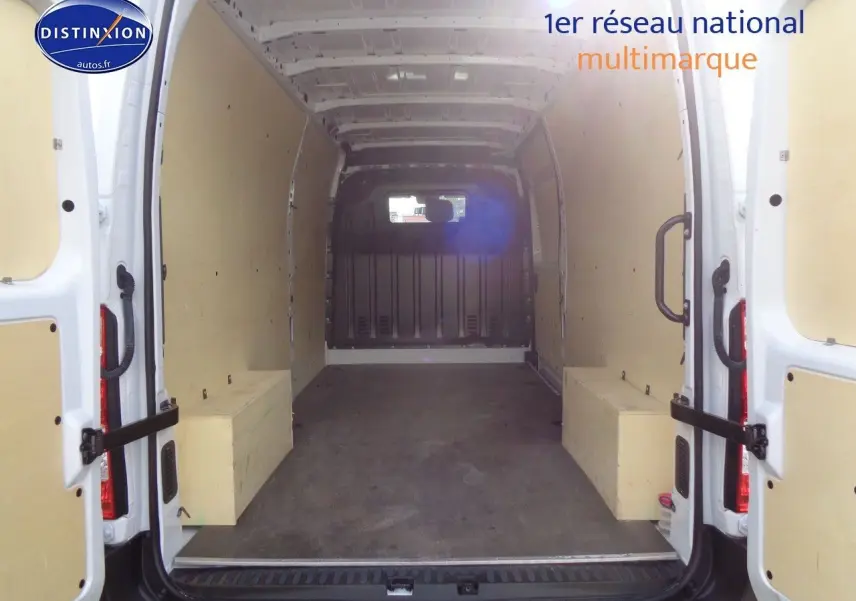 Vue intérieure arrière du fourgon Opel Movano L3H2 blanc polaire, montrant l'espace de chargement vide avec parois protégées.