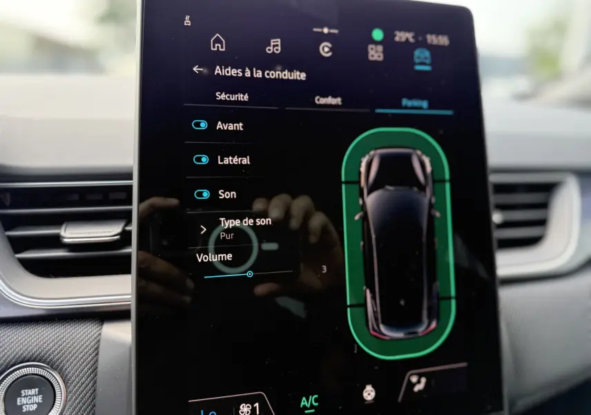 Écran tactile intérieur du Renault Captur 2025 affichant les aides à la conduite et la vue top-down du véhicule noir étoile.