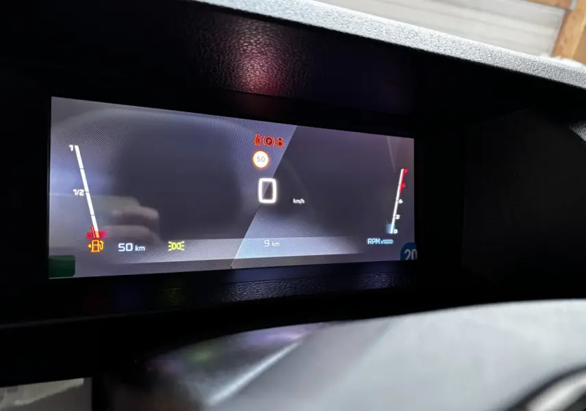 Tableau de bord numérique du Peugeot Expert Fourgon 2025 affichant vitesse, compte-tours et alertes, vue frontale rapprochée.