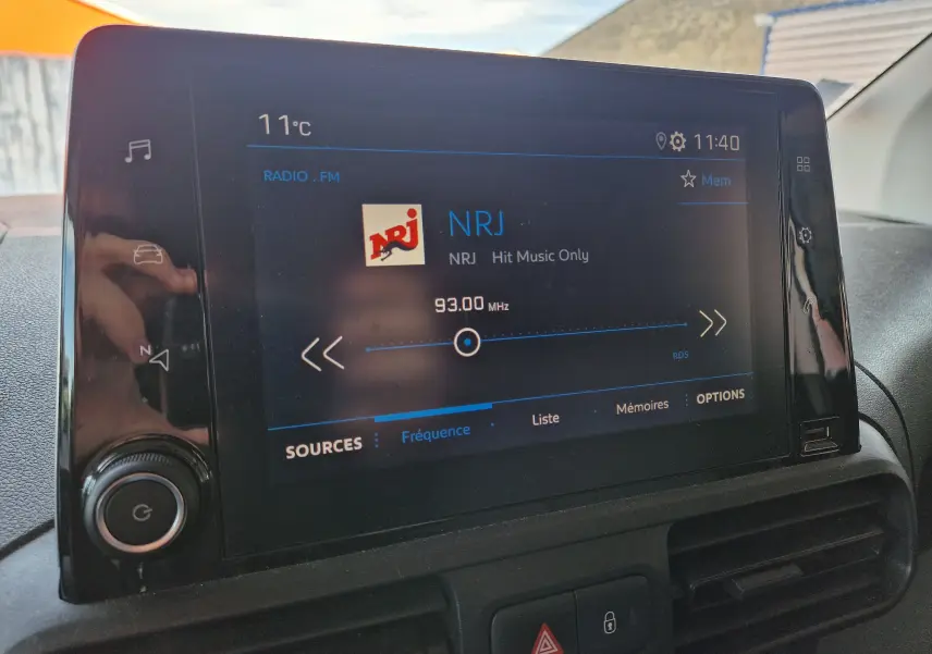 Écran tactile central du Peugeot Partner 2021 affichant la radio NRJ sur 93 MHz avec commandes visibles.