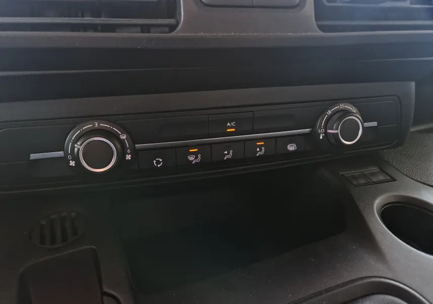 Vue rapprochée de la console centrale du Peugeot Partner 2021, avec commandes de climatisation et réglages en noir.