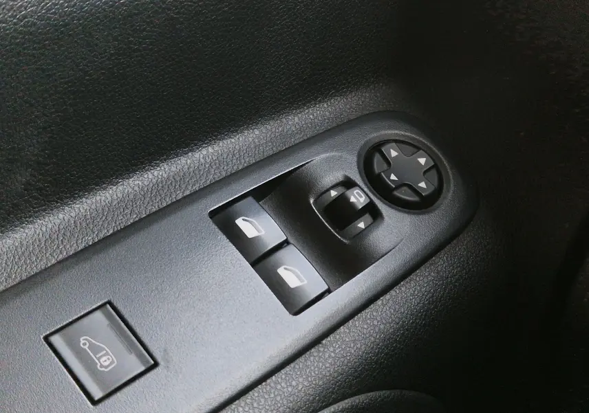 Panneau de commandes des vitres et rétroviseurs côté conducteur du Peugeot Partner gris 2021, vue rapprochée.