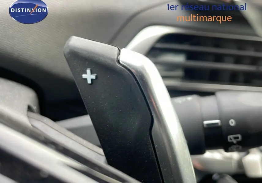 Gros plan sur la palette de changement de vitesse "+" côté droit du volant d'un Peugeot 3008 hybride rechargeable 2024.