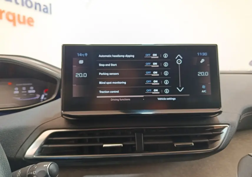 Vue intérieure du tableau de bord central du Peugeot 5008 bleu 2023, avec écran tactile affichant les réglages de conduite.