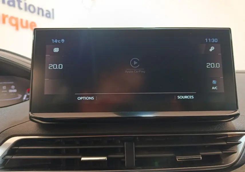 Écran tactile central du tableau de bord du Peugeot 5008 GT 2023 affichant Apple CarPlay et réglages climatisation.