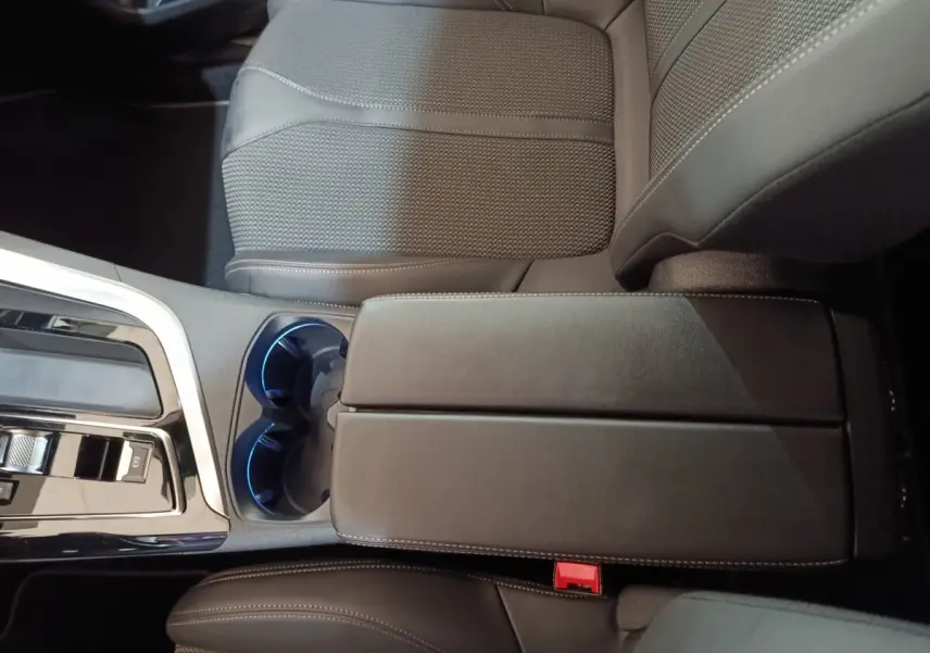 Vue rapprochée de l'accoudoir central noir et des sièges en cuir gris foncé du Peugeot 5008 GT 2023.