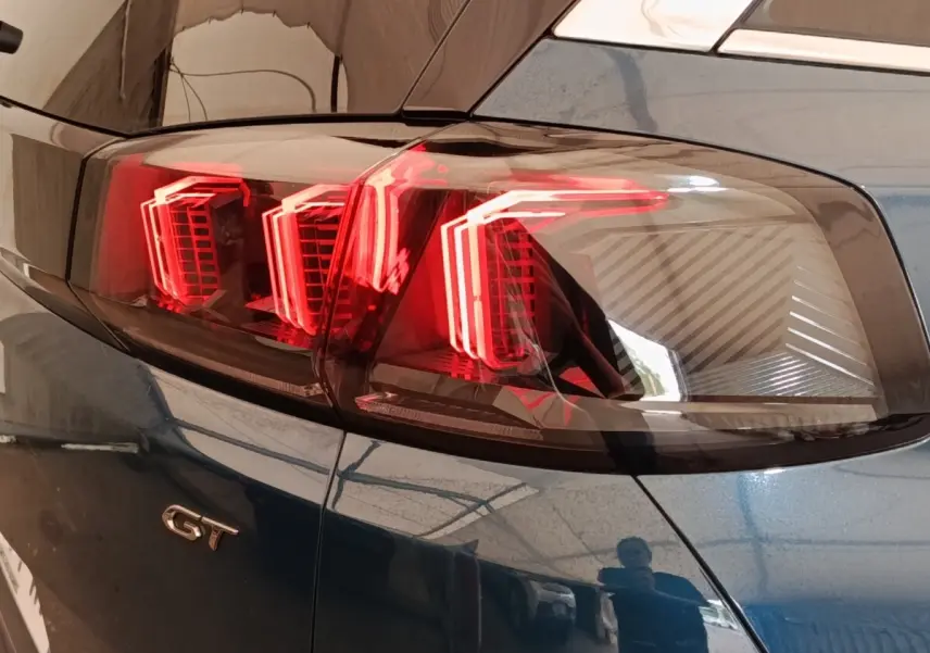Gros plan sur le feu arrière droit rouge et le logo GT du Peugeot 5008 bleu, version PureTech 130 S&S EAT8 GT.