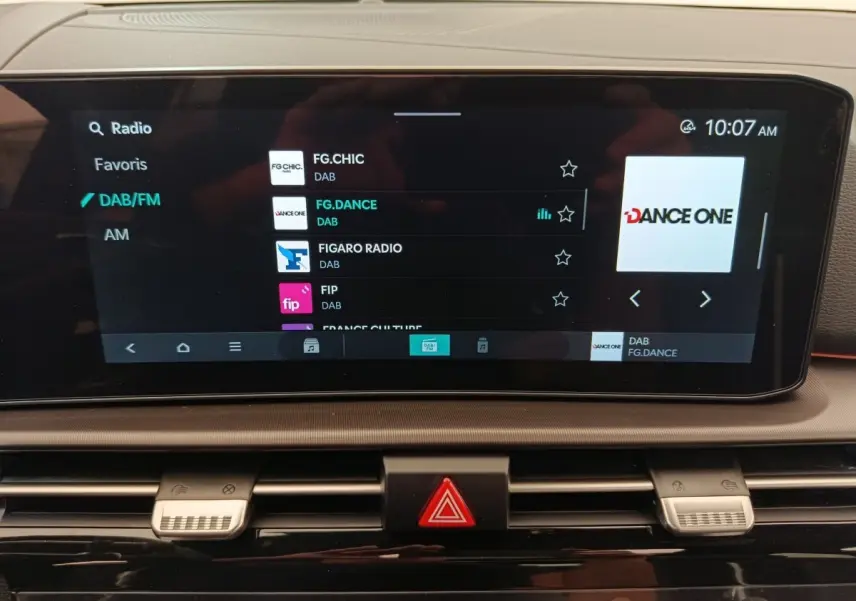 Écran tactile central affichant la radio DAB dans l'habitacle du Kia Sportage gris foncé, vue de face.