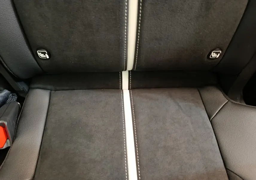 Détail de la banquette arrière en tissu noir avec surpiqûres blanches et fixations Isofix visibles du Kia Sportage 2026.