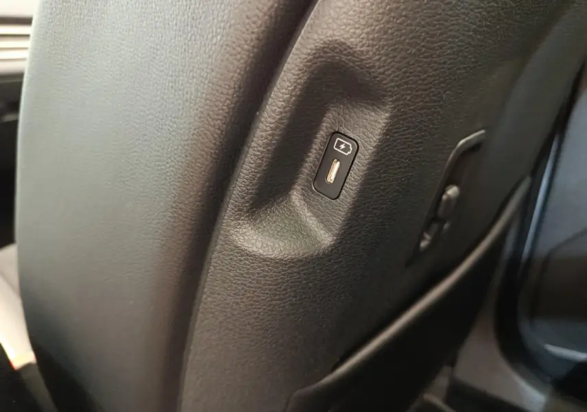 Port USB de recharge intégré au dossier du siège avant droit du Kia Sportage gris foncé 2026.