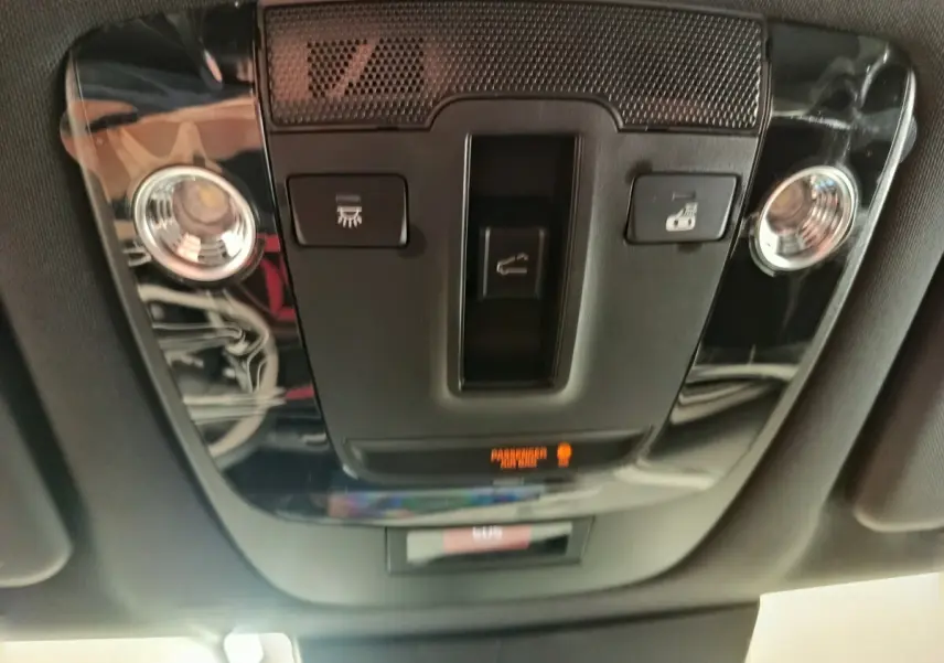 Plafonnier intérieur noir brillant du Kia Sportage 2026 avec commandes d'éclairage et détecteur passager allumé.